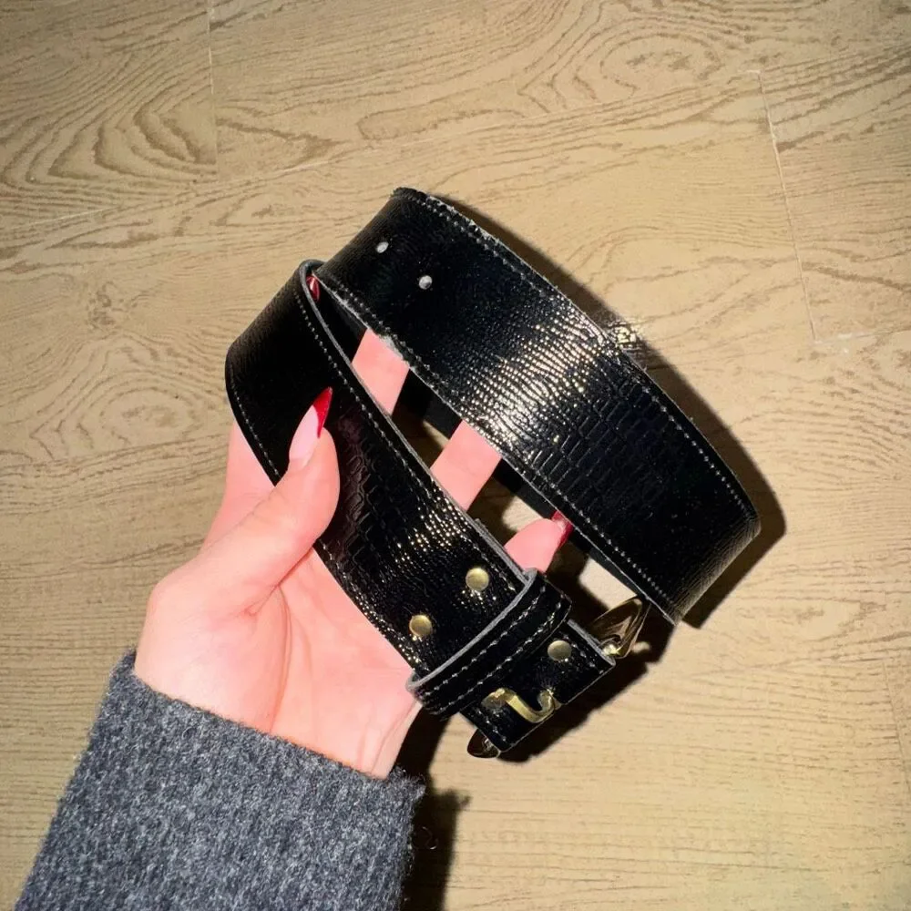 black patent leather belt with a large gold buckle, possibly a vintage 80's styl